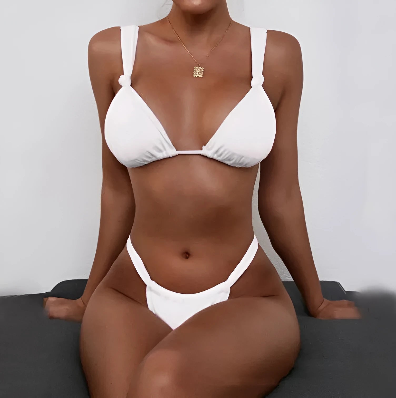 Women's pink pleated knotted bikini swimsuit with split straps on a mannequin.
