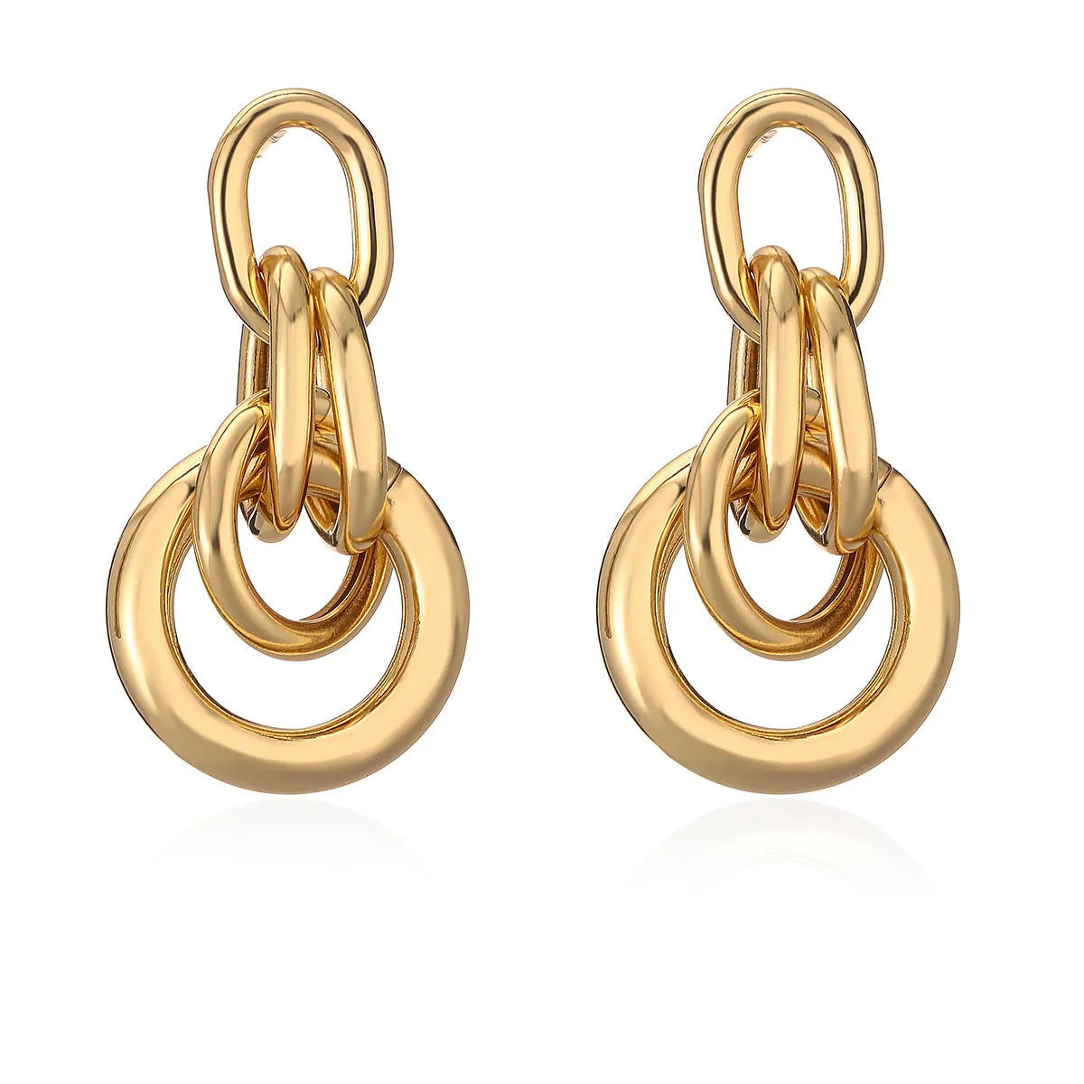 A pair of gold-coloured geometric copper earrings with irregular shapes on a white background.