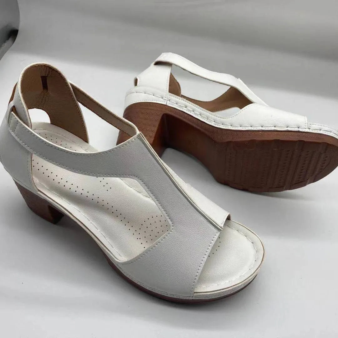 Women's beige peep toe wedge sandals with Roman ankle straps and a buckle closure on a low heel.