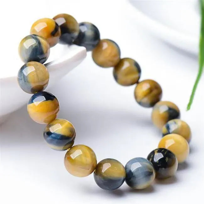 A fantasy tigereye agate bracelet with round geometric beads on a wrist.