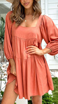 Orange children's backless dress with square collar and puff sleeves, showing A-line skirt.