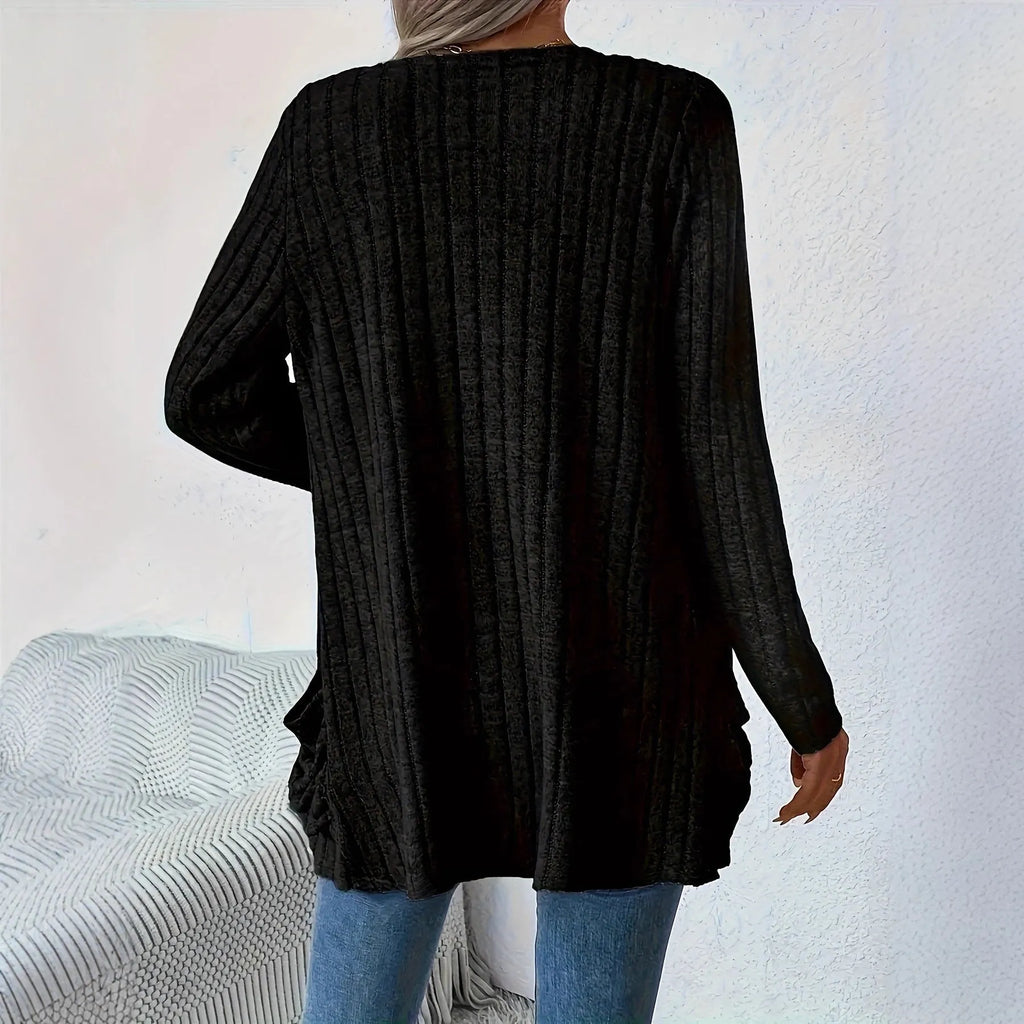 Man wearing a solid grey loose-fit long sleeve cardigan with side pockets.