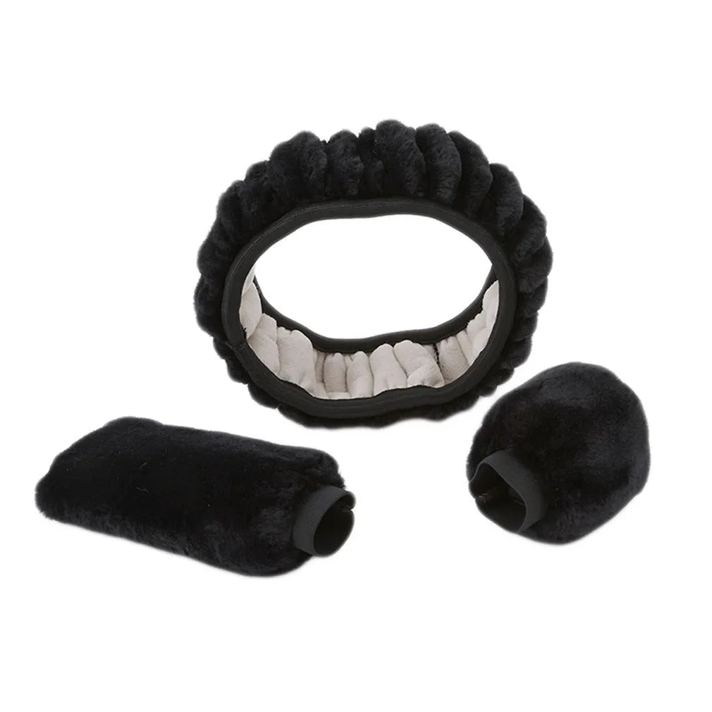 Winter plush car steering wheel cover set in black with matching gear shift and handbrake covers on a dark car interior