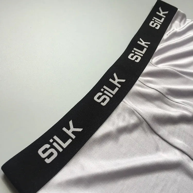 Men's loose fit silk shorts in navy blue, shown on a mid waist.