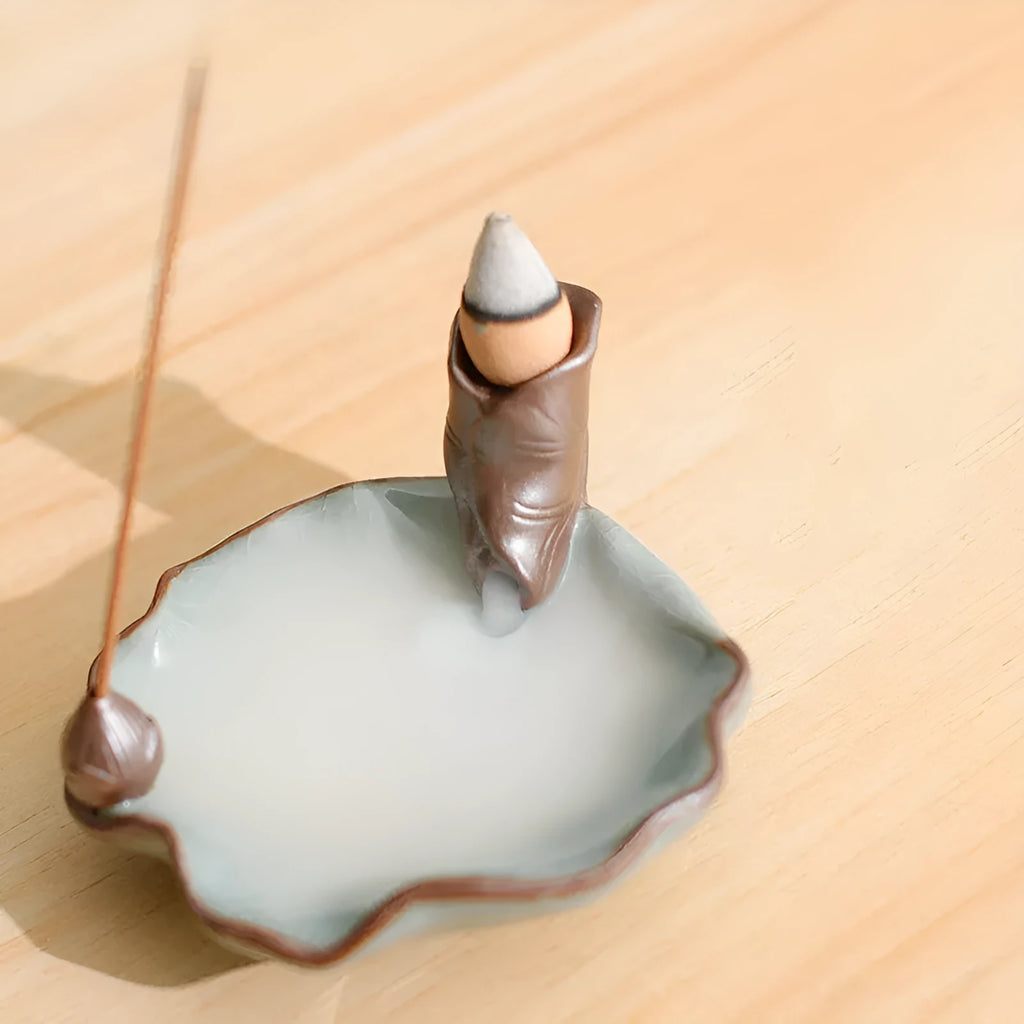 Square ceramic reverse flow incense burner with purple clay finish and lotus plum blossom decoration.