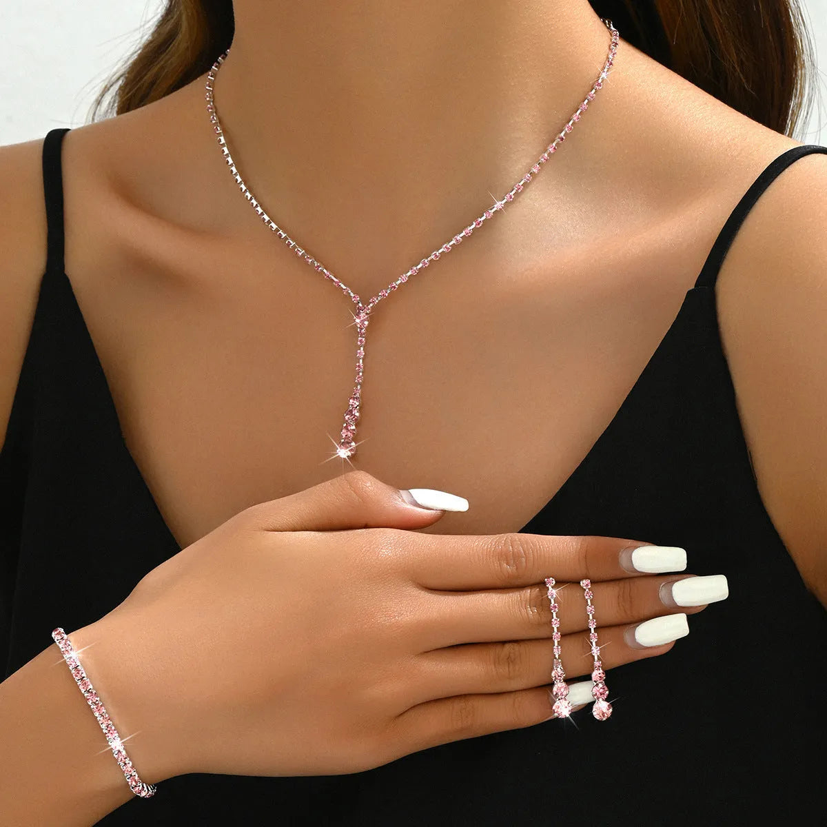 Rhinestone bridal jewellery set includes necklace, bracelet, and earrings in silver with tassel and heart elements