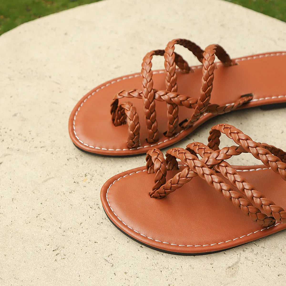 Women's brown clip-toe woven flat sandals on a light background