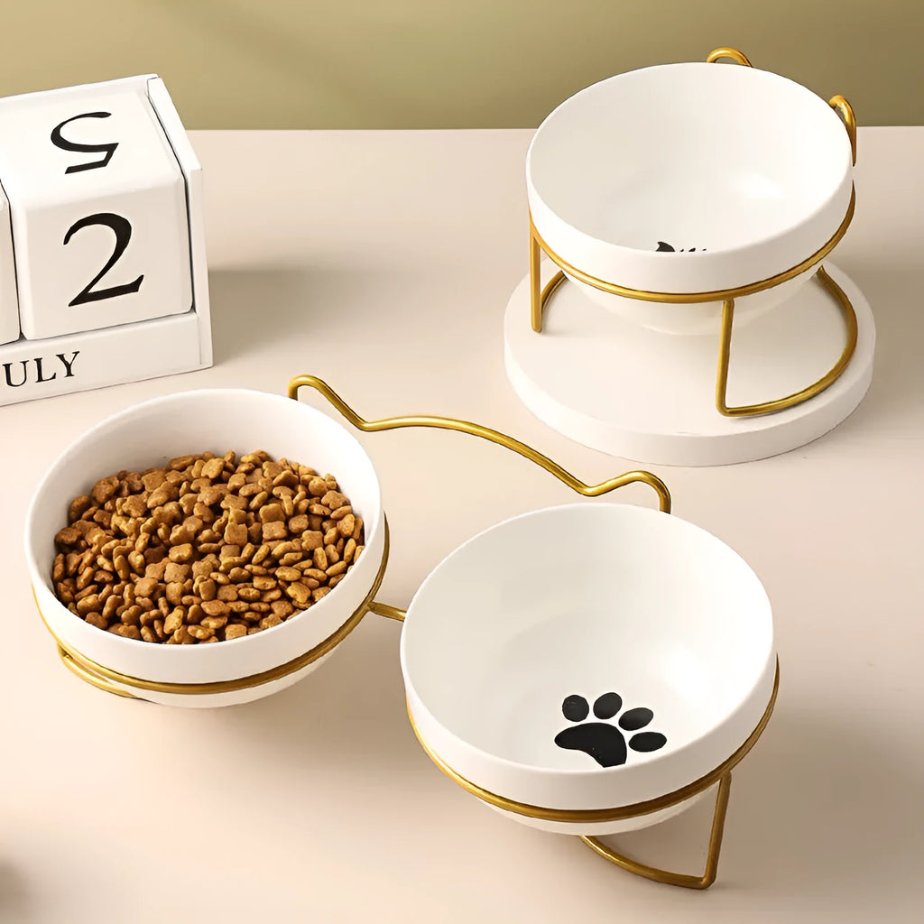 White ceramic cat bowl with cat footprint design in a black iron frame with cat ears.