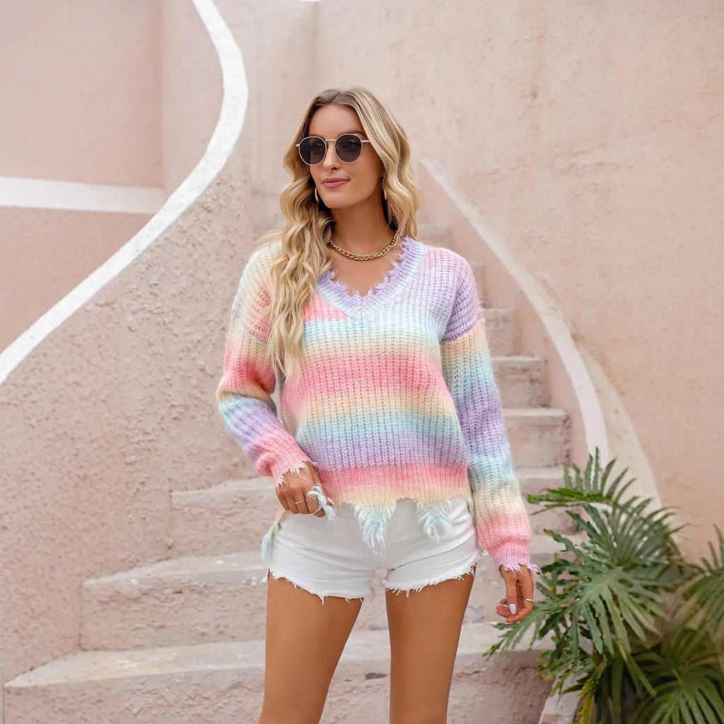Pink loose cut rainbow gradient knitted sweater with tassels on a hanger