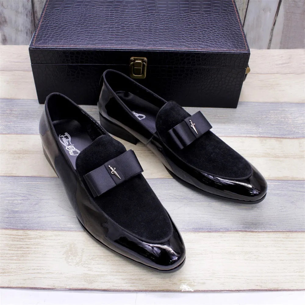 Men's black patent leather dress shoes with a gold tassel detail on the front.