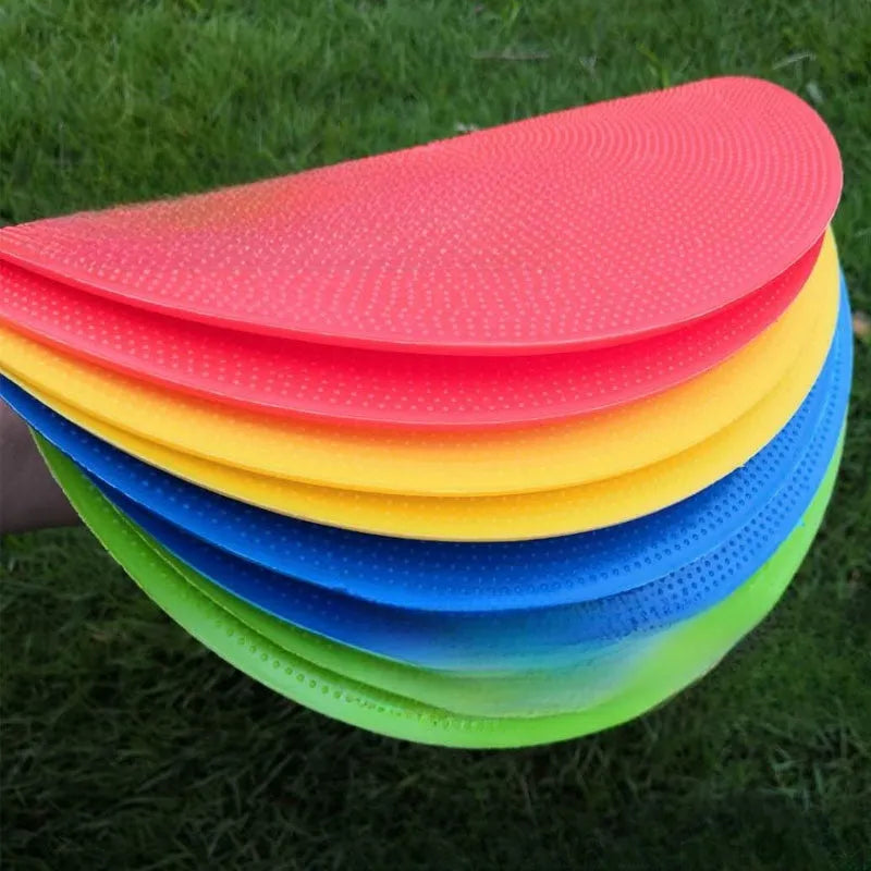 Yellow flexible TPE football training target disc, 23cm diameter, lying flat on grass.