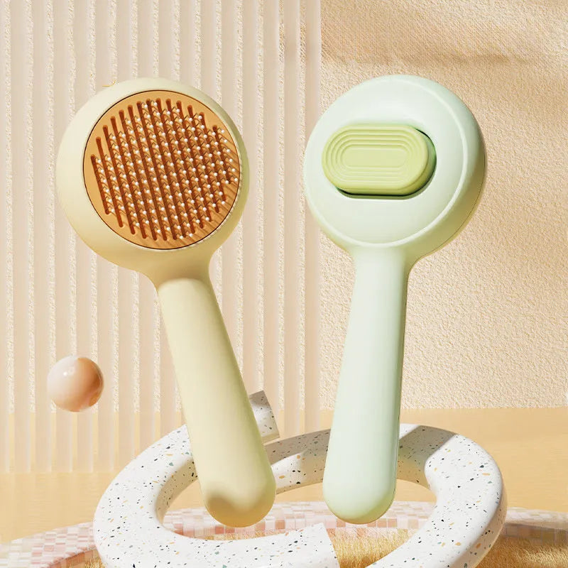 Green and yellow handled stainless steel pet grooming brush for cats and dogs on a white background.