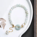 Women's jade bracelet with emerald peace buckle and pearl details in geometric national style design