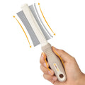 White double-sided pet grooming brush with comb and deshedding head on a curved ergonomic handle.
