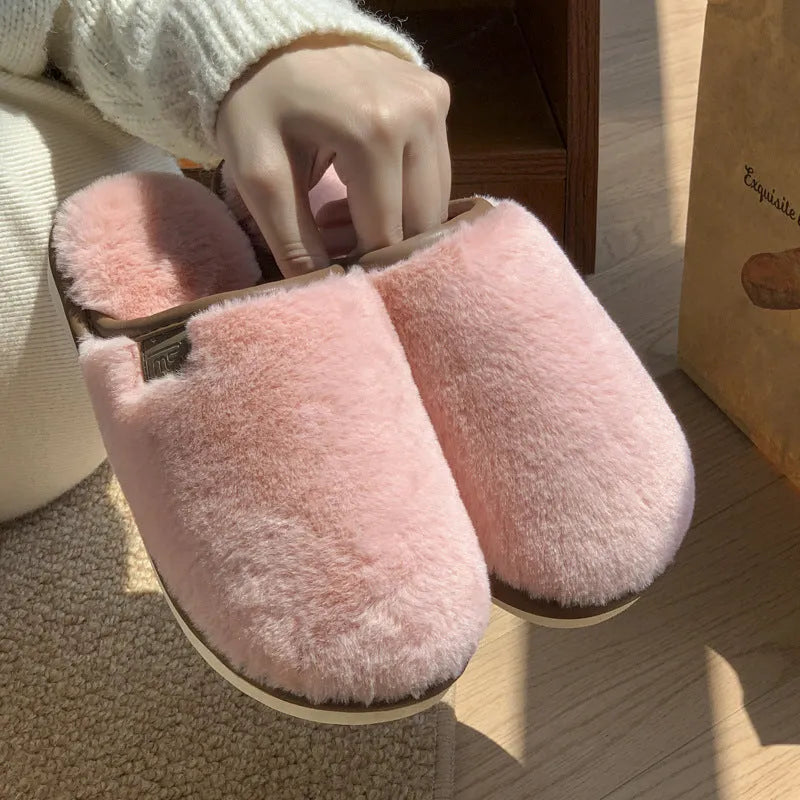Solid colour winter plush slippers with non-slip PVC sole on a wooden floor.