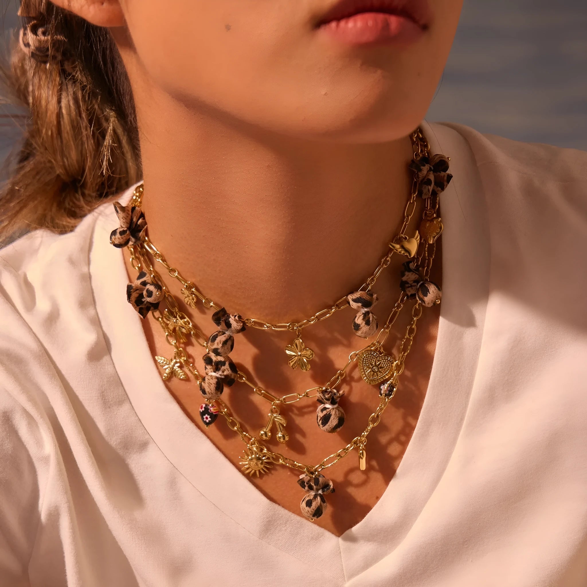 Geometric stainless steel necklace with leopard, heart and flower motifs on 18K electroplated pendant