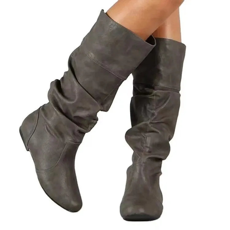 Women's flat heel slip-on boots in black with a round toe and high calf shaft, made from artificial PU with a rubber sole.