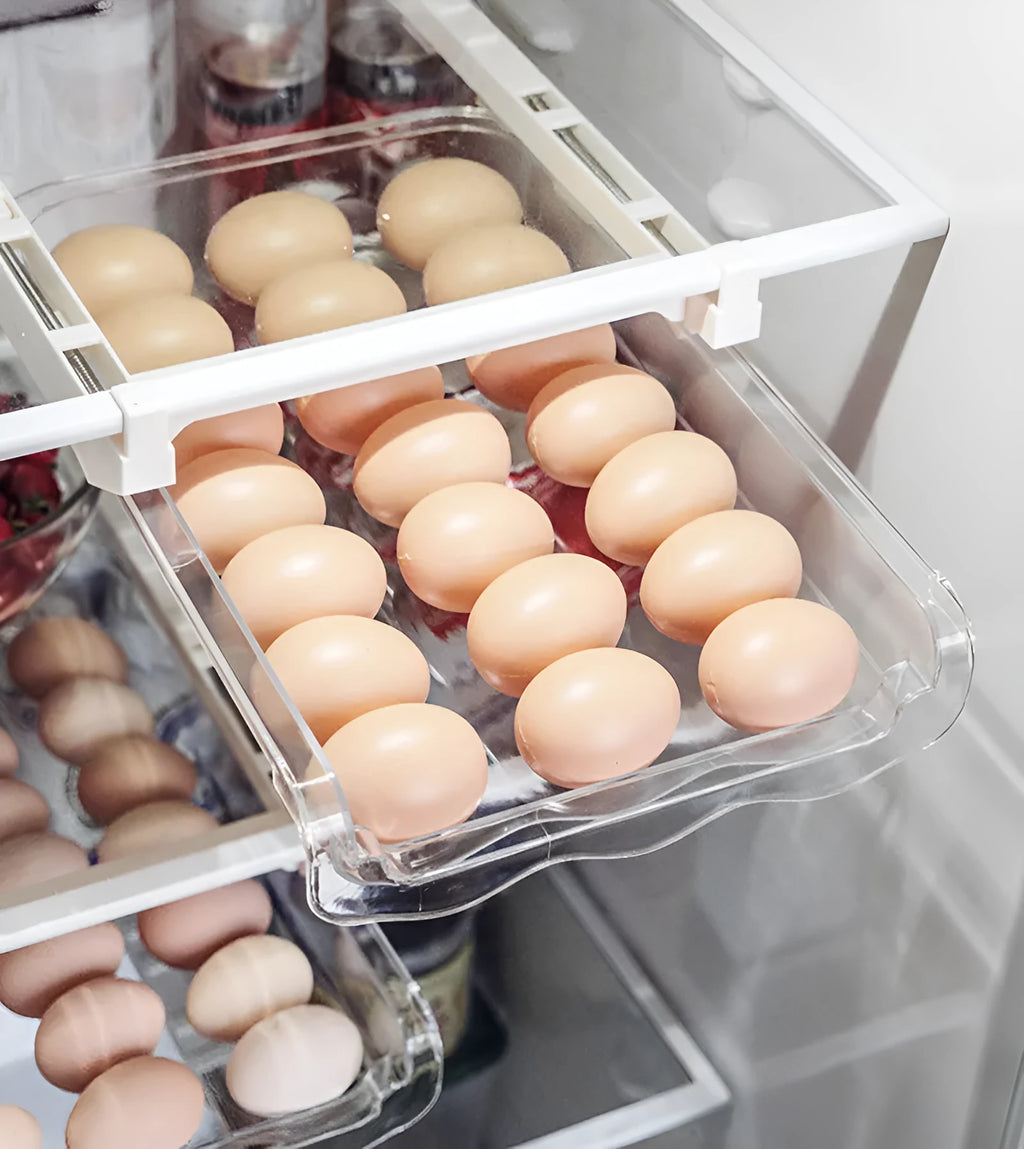 Transparent plastic pull-out egg storage box with stackable design on a refrigerator shelf