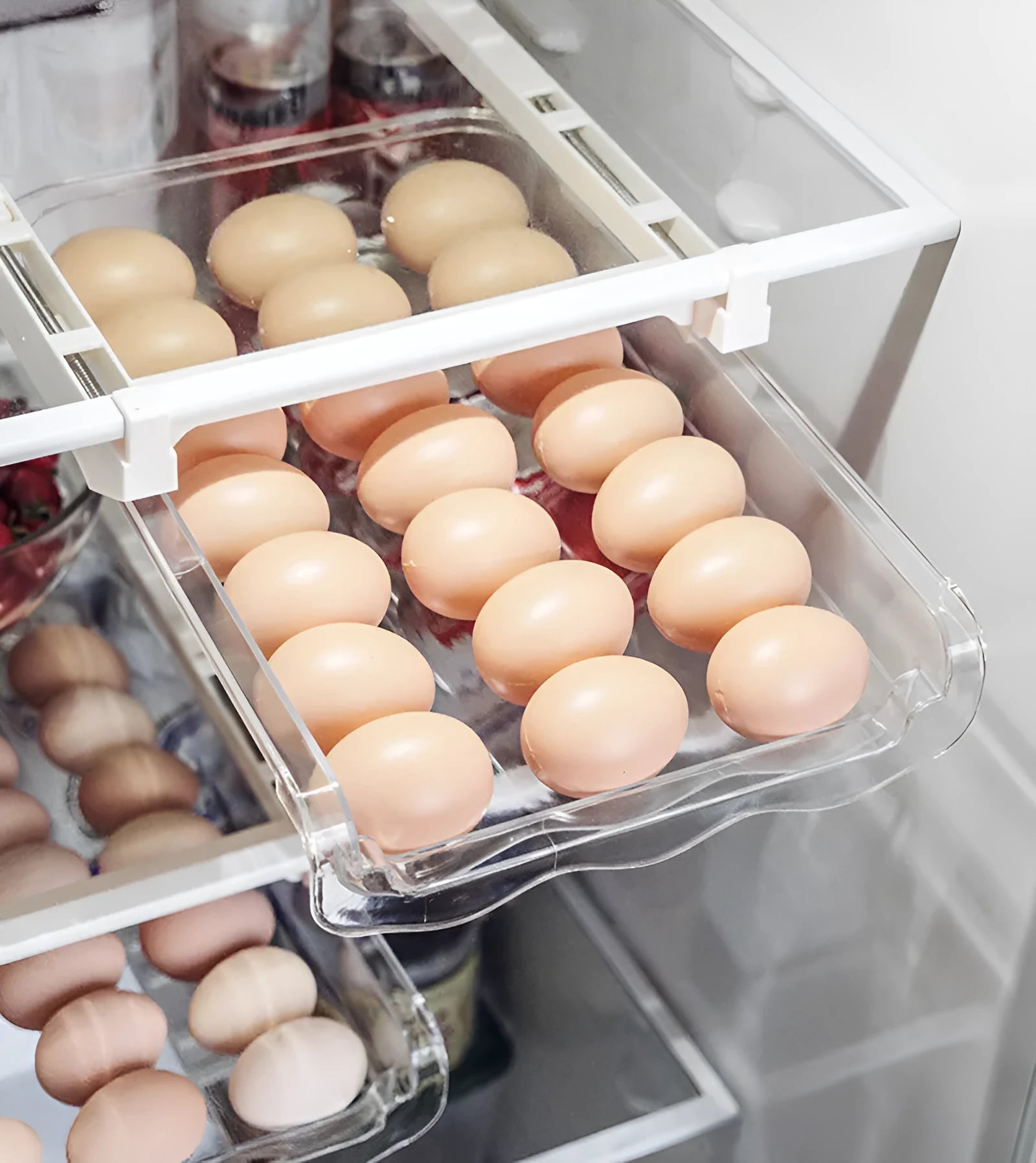 Transparent plastic pull-out egg storage box with stackable design on a refrigerator shelf