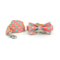 Yellow polka dot dog collar with bow and matching hand-held traction rope on white background