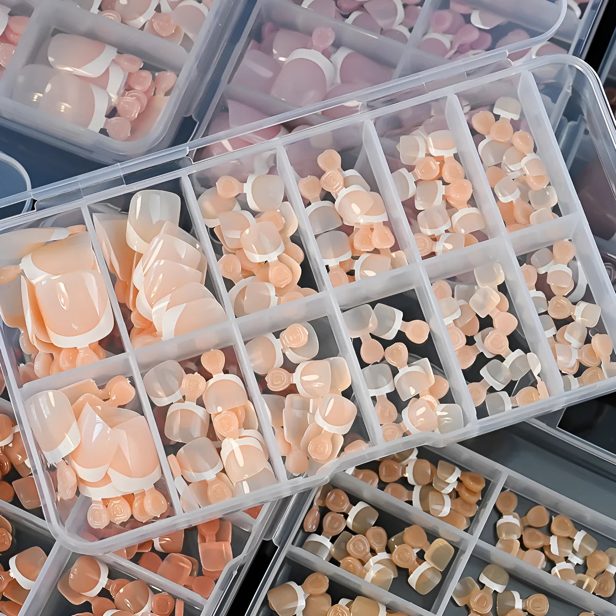Box of 120 French white edge nude square short toe nail pieces in nine shades.