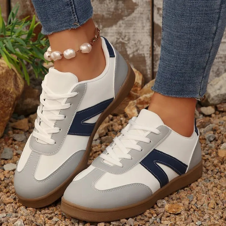 Women's blue flat German training shoes with artificial PU upper and rubber sole, low-top profile, side view
