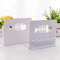 Pair of white steel Nordic bookends with six-hole pen holder and Japanese hollow design on a wooden desk
