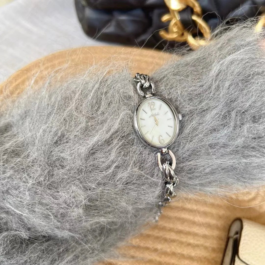 Lady's steel strap quartz watch with oval hollow chain in gold case gold face design