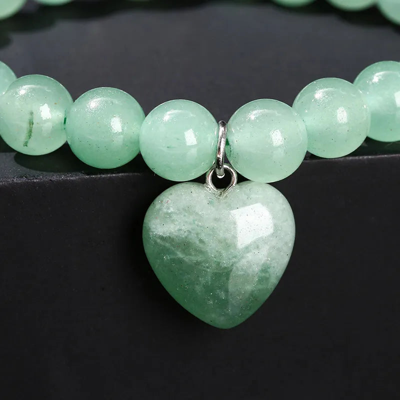 Natural stone love pendant hand bracelet with tigereye beads and geometric heart pendant on white background