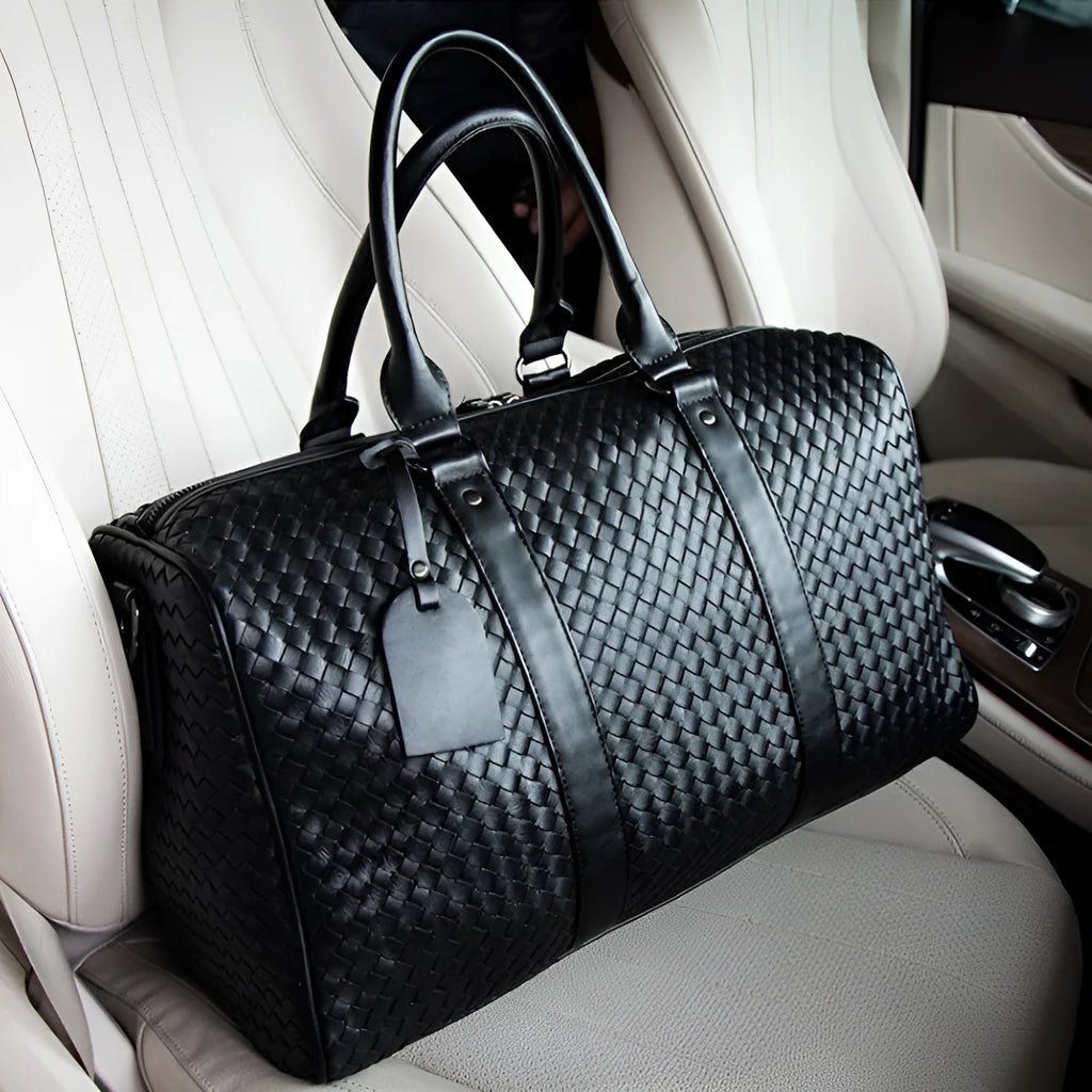 Black handwoven PU leather shoulder bag, medium size, zip closure, tie-rod fitting, on beige background