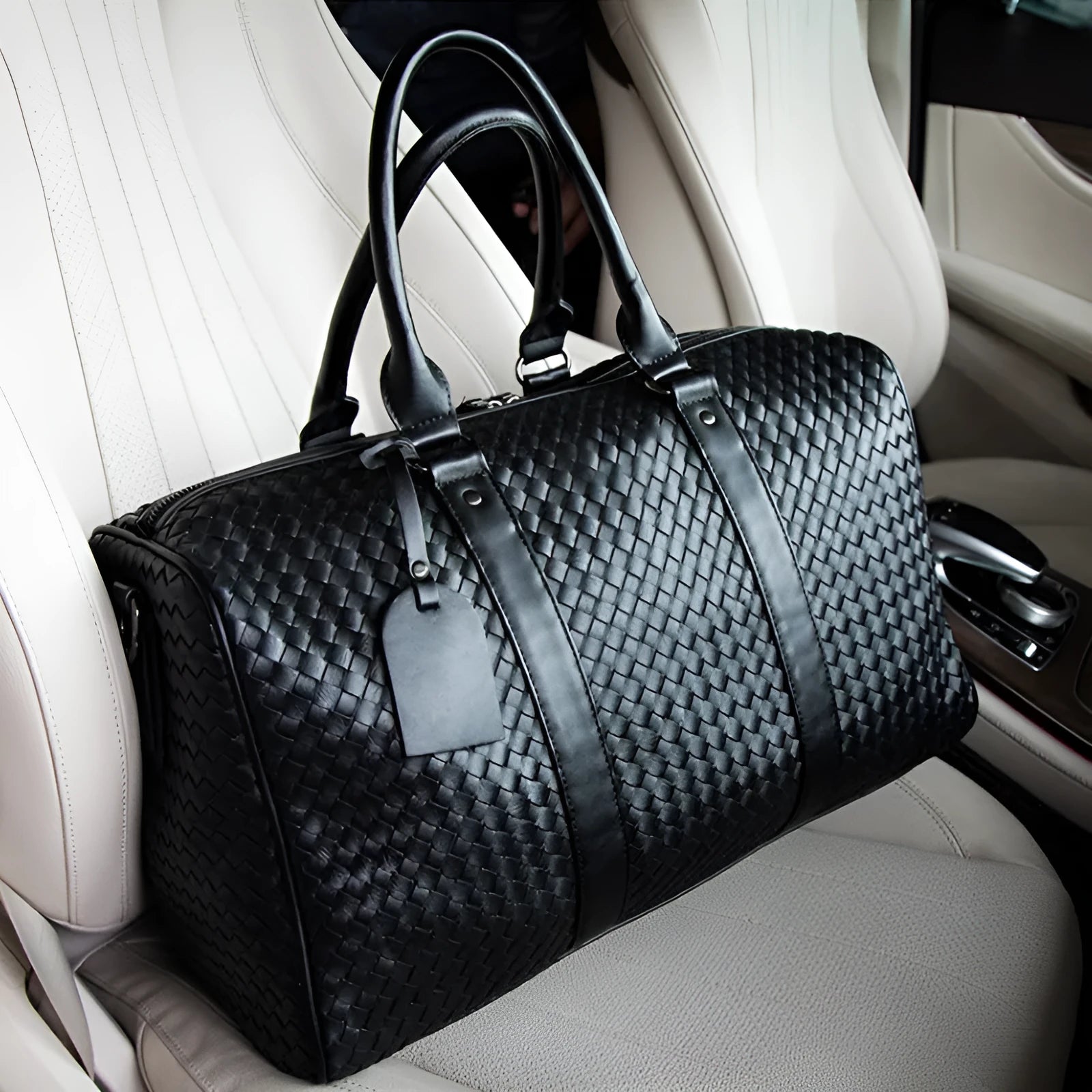 Black handwoven PU leather shoulder bag, medium size, zip closure, tie-rod fitting, on beige background