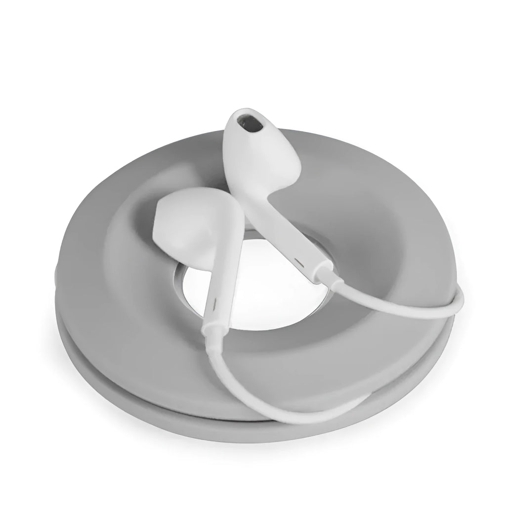 Donut silicone suction cup cord reel in green with earphone cable wound around it and magnet ring closed