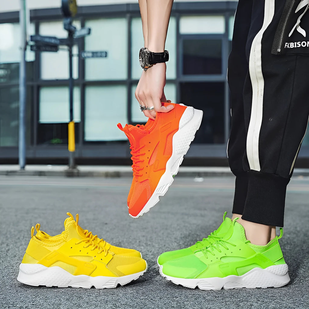 Men's green low top lace-up casual trainers with mesh upper and cross strap detail on a white background.