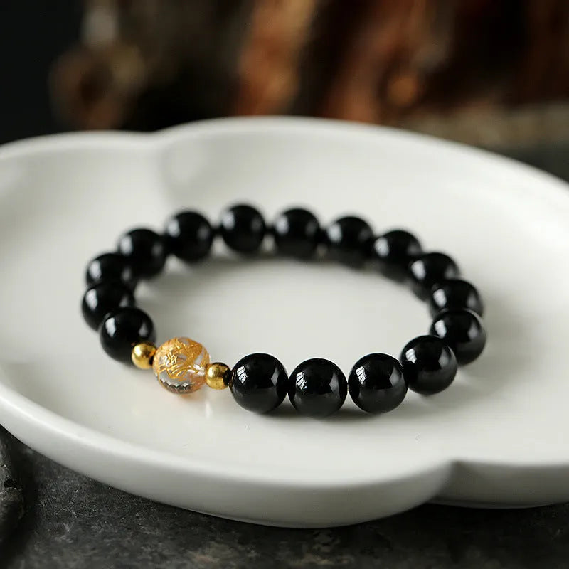Unisex obsidian black agate and white crystal beaded bracelet on a neutral background, 10mm and 8mm beads