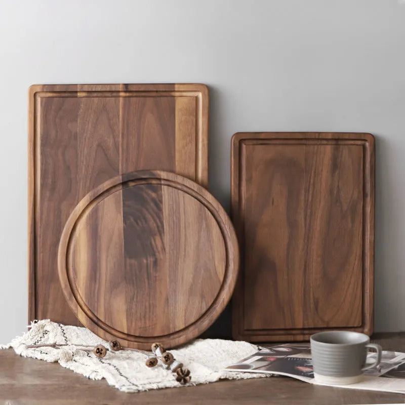 Black walnut wood cutting board with groove edge, rectangular shape, on kitchen counter