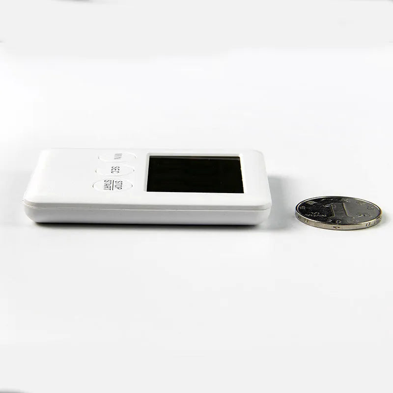 Black and white magnetic kitchen timer clock with digital display on a metal surface.