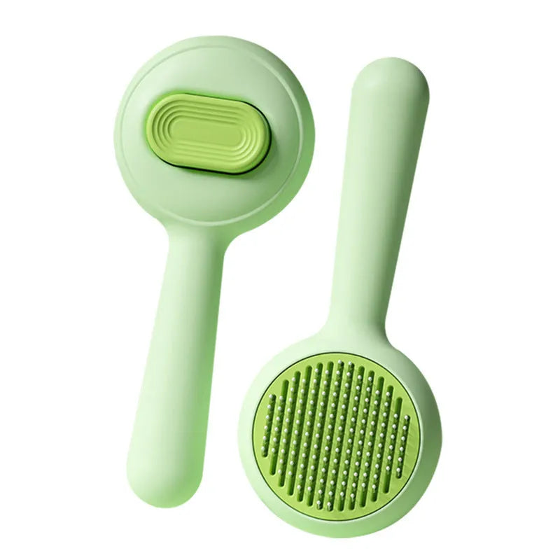 Green and yellow handled stainless steel pet grooming brush for cats and dogs on a white background.