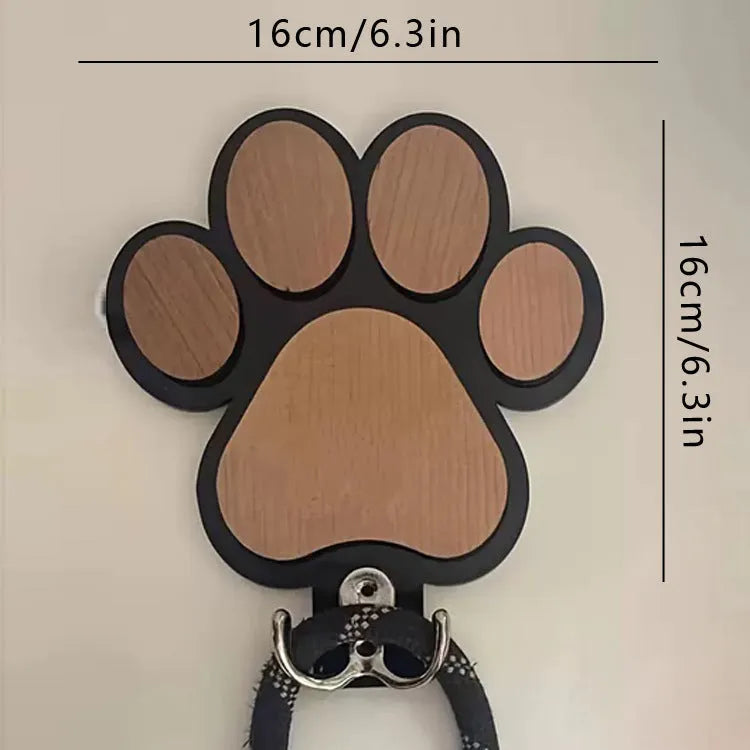 Wooden foot paw print hook in black colour on a white wall for household organisation
