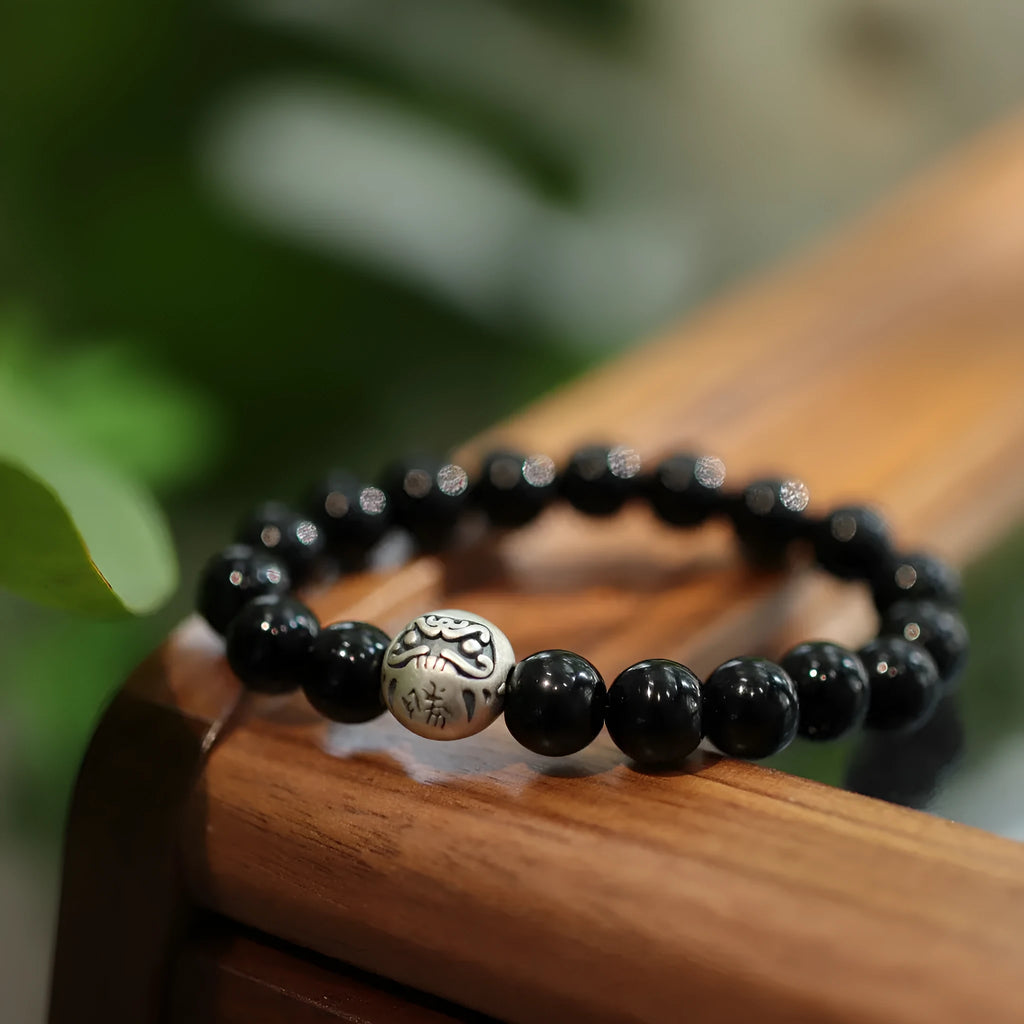 Women's black agate bracelet with sterling silver clasp showing 10mm stones and Chinese style design.