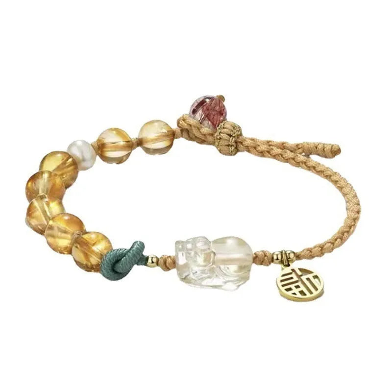 Hand-woven citrine crystal bracelet with zodiac design on neutral background