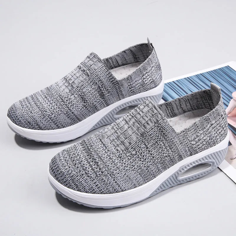 Women's beige mesh running shoes with air cushion midsole on a neutral background.