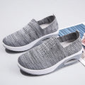 Women's beige mesh running shoes with air cushion midsole on a neutral background.