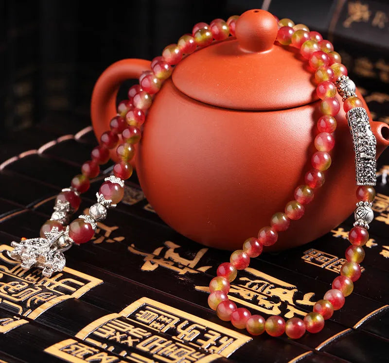 Handmade geometric bracelet made from natural watermelon crystal beads with a traditional Chinese knot clasp.