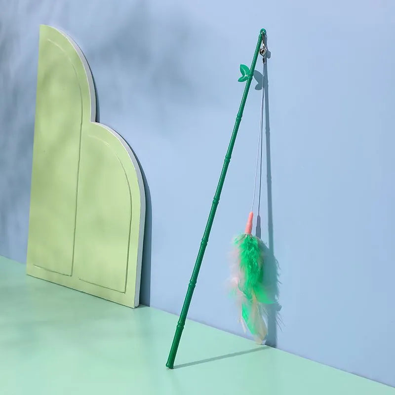 Green interactive cat toy feather wand with bell refills and feathers on a white background