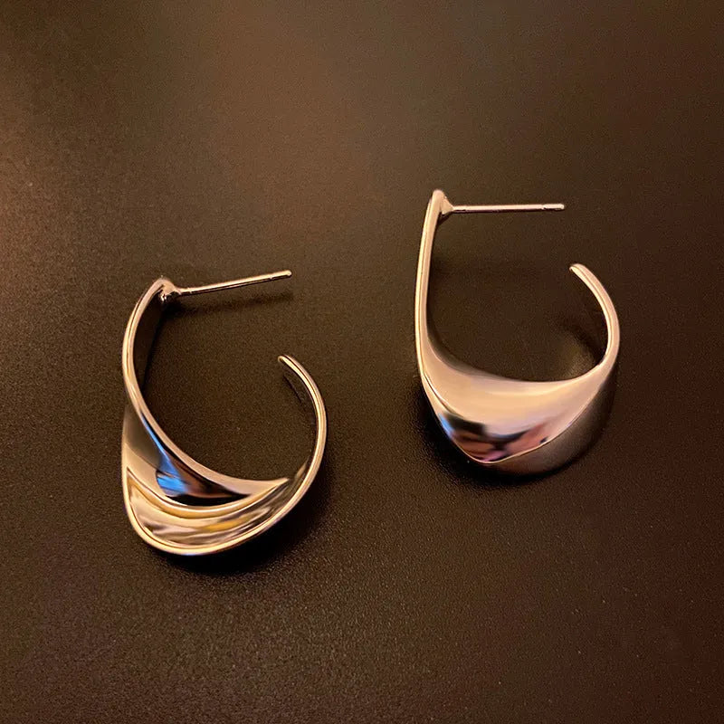 Gold twisted geometric metal earrings with round design elements