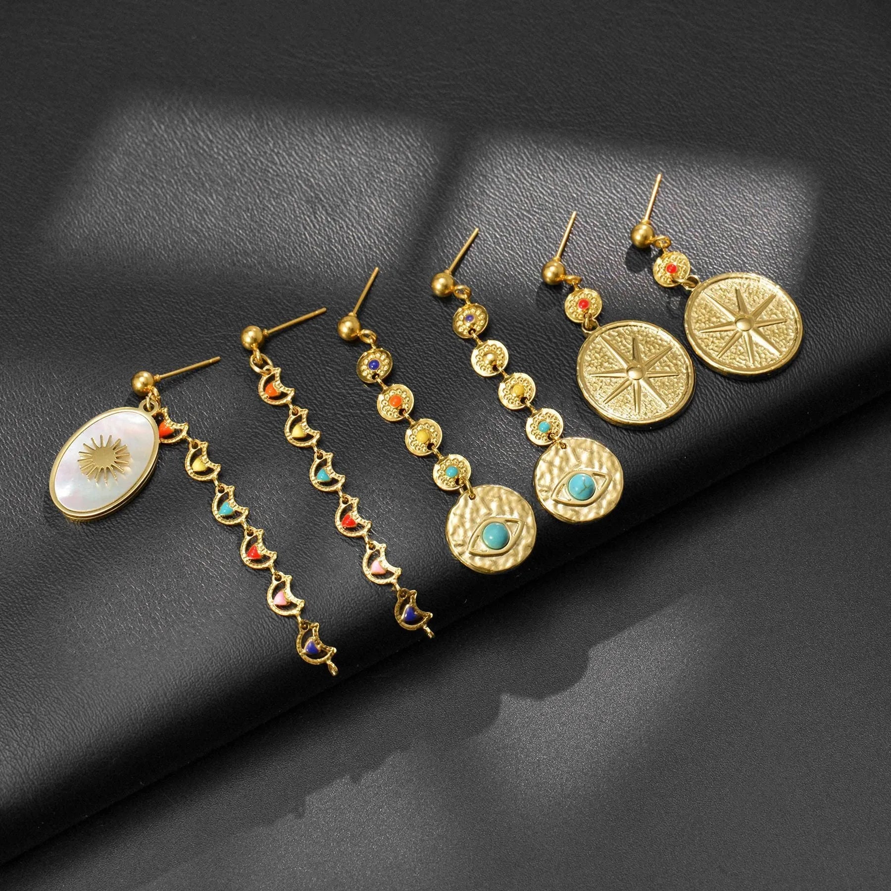 Geometric stainless steel earrings showing eight-awl-star, eye and shell-sun design variations