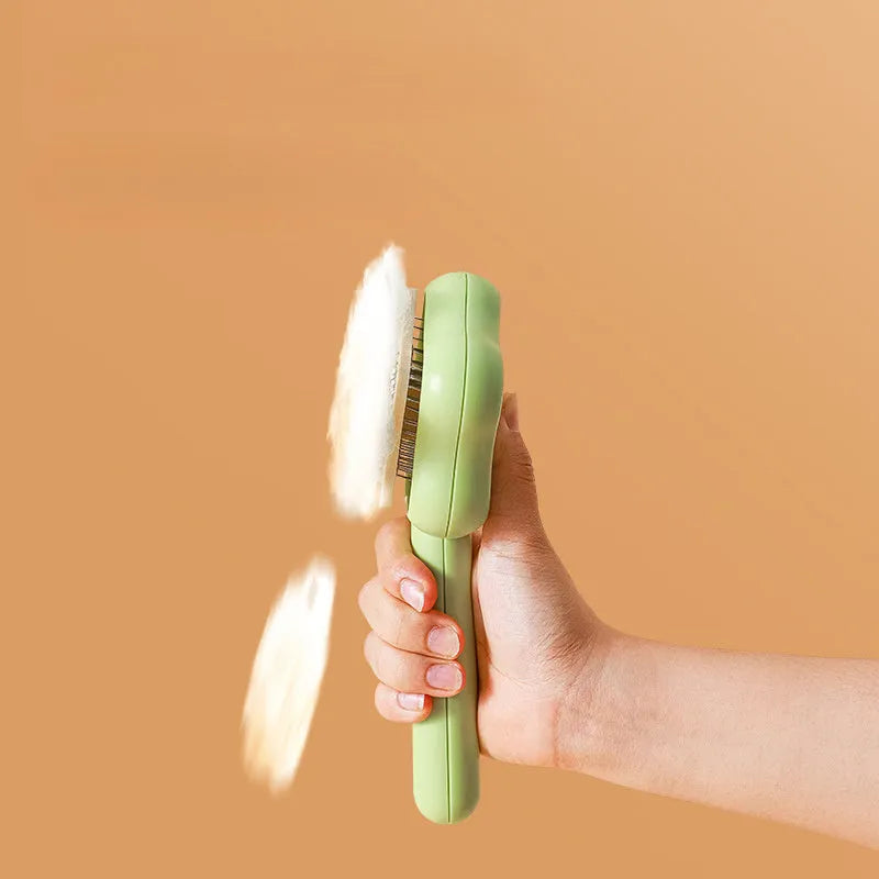 Green self-cleaning stainless steel pet comb for grooming cats and dogs on a white background