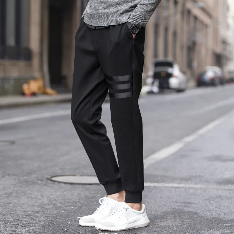 Men's casual slim sweatpants in black with elastic waistband and drawstring, side pockets, tapered leg, polyester fibre fabric