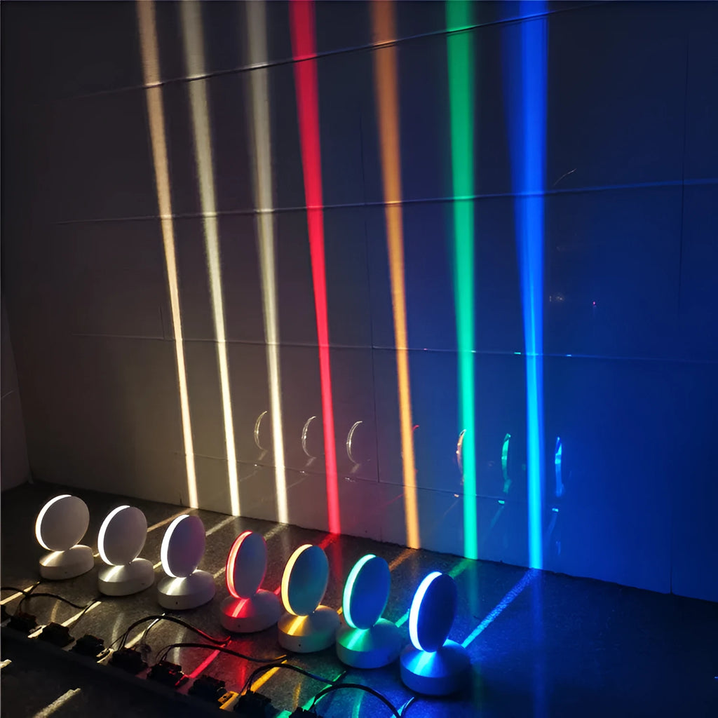 Modern aluminium LED spotlight bar wall lamp emitting coloured light, mounted on a wall.