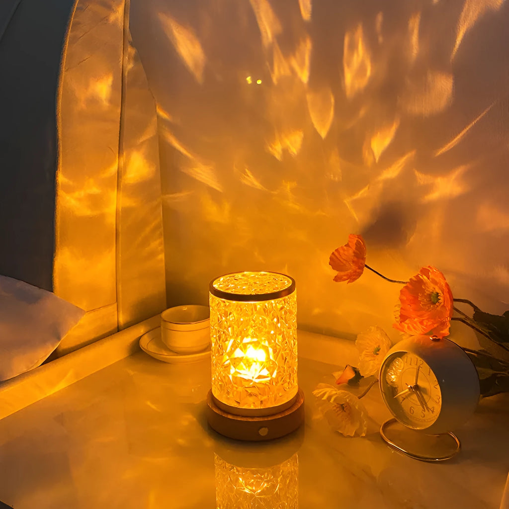Small modern acrylic and wood water ripple night light with rotating base on a bedside table.